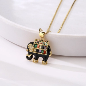 Macro shot of gold elephant pendant with black enamel and colorful zircon stones