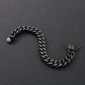 Close-up of black metal Cuban link bracelet with clasp on black leather background