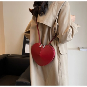 Borsa a tracolla rossa a forma di cuore in pelle indossata per mostrare la misura