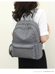 Vista lateral de la mochila acolchada gris con múltiples compartimentos con cremallera