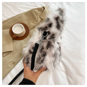 Detailed view of plush black and white spotted crescent bag with leather strap and metal buckle