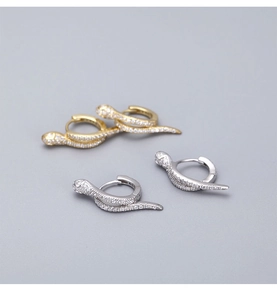Macro shot of silver and gold snake earrings with micro-pave cubic zirconia details