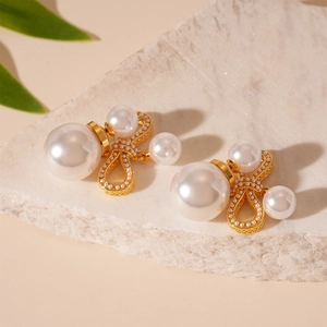 Detailed macro shot of gold bow earrings featuring lustrous pearls and micro-pearl inlay