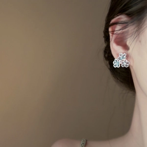 Vue détaillée des boucles d'oreilles fleurs avec pétales bleus sur le mannequin