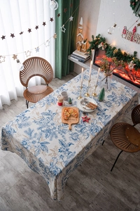 Close-up of blue pine print rectangular tablecloth in a festive Christmas dining setting