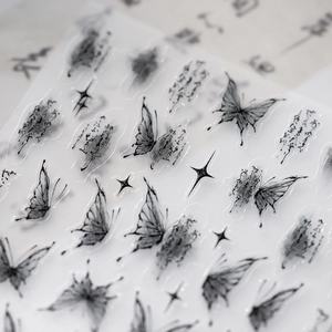 Ink butterfly nail stickers with artistic calligraphy and sparkling star elements