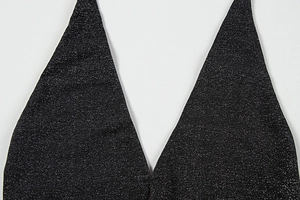 Detailed close-up of sparkling black sequin fabric with sexy deep V-neckline design