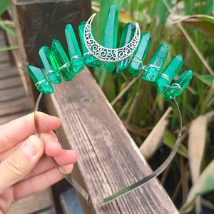 Detailed close-up of a handmade silver moon tiara with vertical green crystal pillars