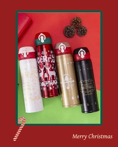 Detailed view of four stainless steel Christmas thermoses with festive deer and tree patterns