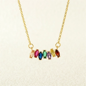 Close-up of golden necklace with seven marquise-cut colorful gemstones in a linear row