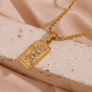Detail of 18K gold tarot pendant with hourglass star pattern on light stone