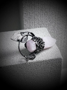 Detailed view of pink crystal hexagonal pendant with silver leaf and vine textures