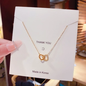 Detail of rose gold double heart pendant necklace held on a Thank You gift card