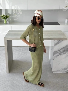 Detail of green crochet knit texture on the short-sleeved cardigan and long skirt set