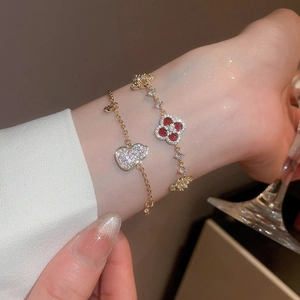 Detailed shot of 18k gold plated bracelet featuring red clover and gourd zircon charms