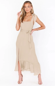 Detail of elegant beige dress featuring a square neck and bow-tie shoulder straps
