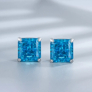 Macro detail of square-cut blue sapphire earrings with silver four-prong setting