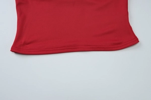 Detail shot of a red summer top hemline showing high-quality double-stitch sewing craft