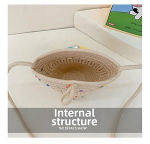 Top view showing the internal woven texture and pearl closure of the straw bucket bag