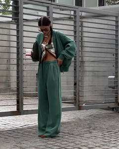 Details des grünen Sweatshirts mit Reißverschluss und der weiten Hose für Damen im Streetstyle