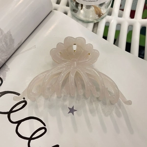Detailed macro shot of a large pink floral acetate hair claw clip with elegant petal textures