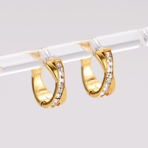 Detail of gold crisscross hoop earrings with clear square gemstones on a display