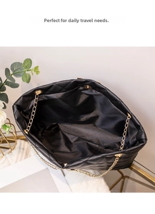 Gros plan sur le sac fourre-tout noir matelassé avec détail élégant de chaîne dorée fine