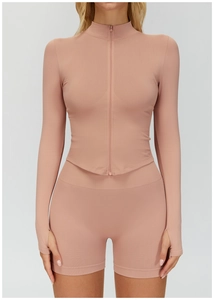 Détail de la veste de yoga rose côtelée montrant le col montant, le zip et les passe-pouces
