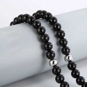 Close-up of 8mm black onyx beads with silver metal accent on a display stand
