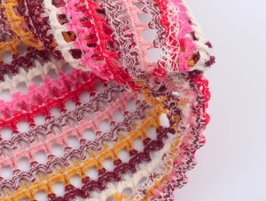 Detailed close-up of multicolor crochet striped fabric with hollow out knit patterns