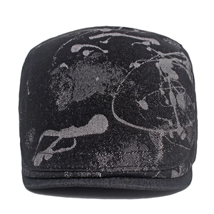 Close-up of black denim beret featuring grey abstract graffiti patterns and fine stitching