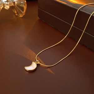 Détail du collier à maille serpent dorée avec pendentif croissant en nacre