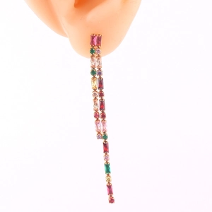 Detailed macro of colorful baguette-cut gemstone long tassel earrings on a display model