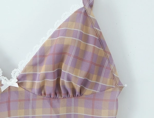 Detailed view of plaid fabric with white crochet lace trim and a decorative ribbon bow