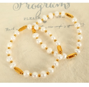 Detail view of freshwater pearl bracelet with golden metal accents on beige card
