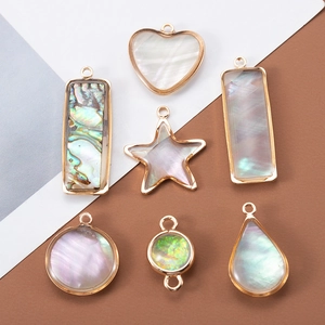 Natural shell pendants in gold metal frames with iridescent luster for jewelry making