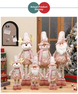 Detailed view of pink fabric Christmas dolls including elk and snowman on a wooden table