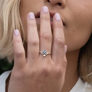 Detailed view of an S925 silver gold-plated ring with a square blue crystal on finger