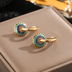 Bohemian gold hoop earrings with colorful enamel floral discs on textured jewelry case