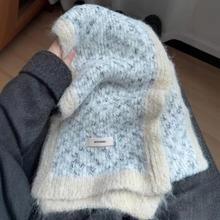 Detail of light blue knitted hat with handmade label and soft white plush trim