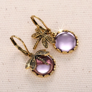 Makroansicht der Vintage-Libellen-Ohrringe mit lila Edelsteinen und goldenem Finish