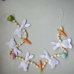 Detail of Easter bunny garland with purple felt rabbits and woven carrots on grey background