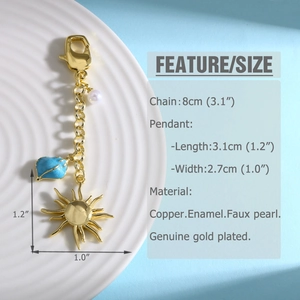 Detail of gold-plated sun and blue enamel leaf keychain with pearl and lobster clasp