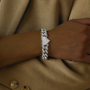 Hip hop silver Cuban chain bracelet with sparkling rhinestone heart pendant on a model