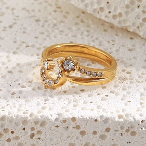 Macro view of 18K gold plated moon ring with white zircons on white porous stone