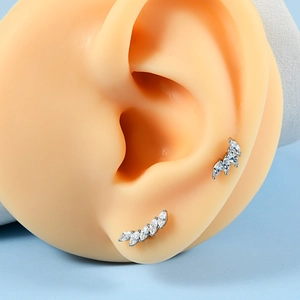 Détail macro de clous d'oreilles en zircon marquise portés sur le lobe et le cartilage