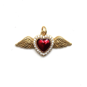 Detailed macro view of golden heart pendant with red stone and sparkling wings