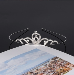 Detail of silver bridal crown with sparkling rhinestones placed on an open book
