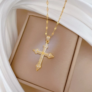 Detailed macro view of gold-plated cross pendant necklace with micro-pave zircons in a gift box