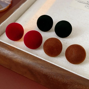 Detailed view of red, black, and brown flocked stud earrings on a display tray